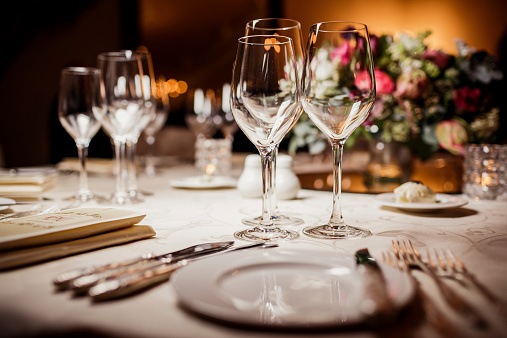 A table set with wine glasses and silverware.