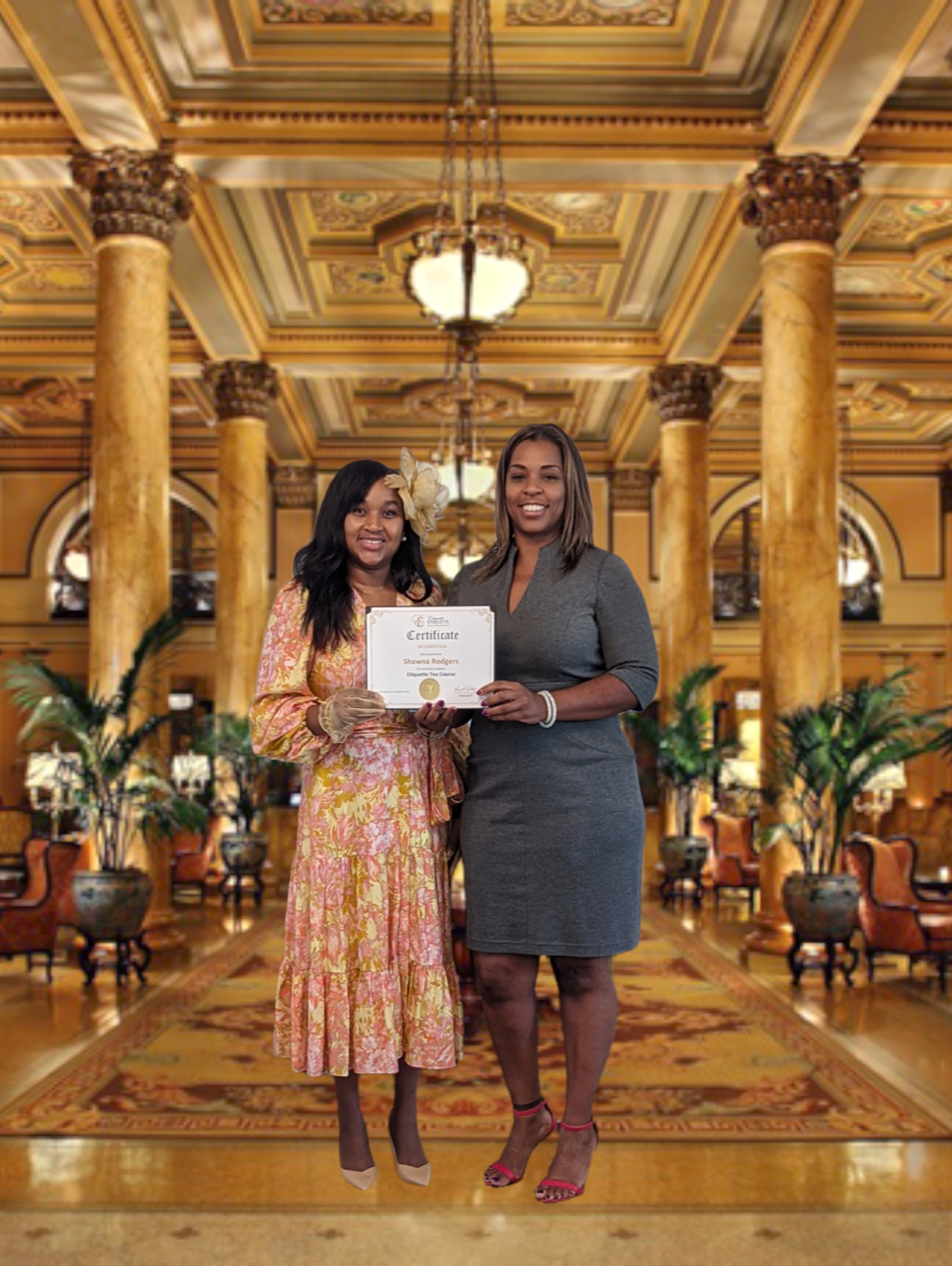 Two women standing in a lobby holding an award.